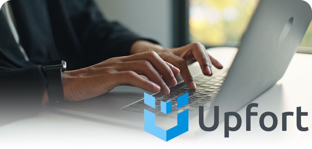 Hands typing on a laptop keyboard with a blue Upfort logo watermark in the corner.