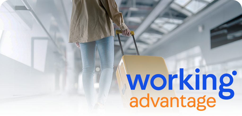 Person pulling a yellow rolling suitcase through a bright, modern corridor with the 'working advantage' logo in blue and orange.